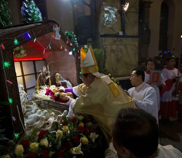 Chinese bishop Joseph Li Shan places a statue of baby Jesus in a replica of a stable as he takes part in a mass on the eve of Christmas at the South Cathedral official Catholic church in Beijing, China, Wednesday, Dec. 24, 2014. (AP Photo/Ng Han Guan)